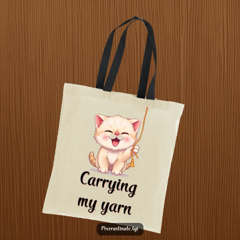 Funny giggling kitten playfully batting at a dangling string of yarn, showcased on a durable and charming tote bag.